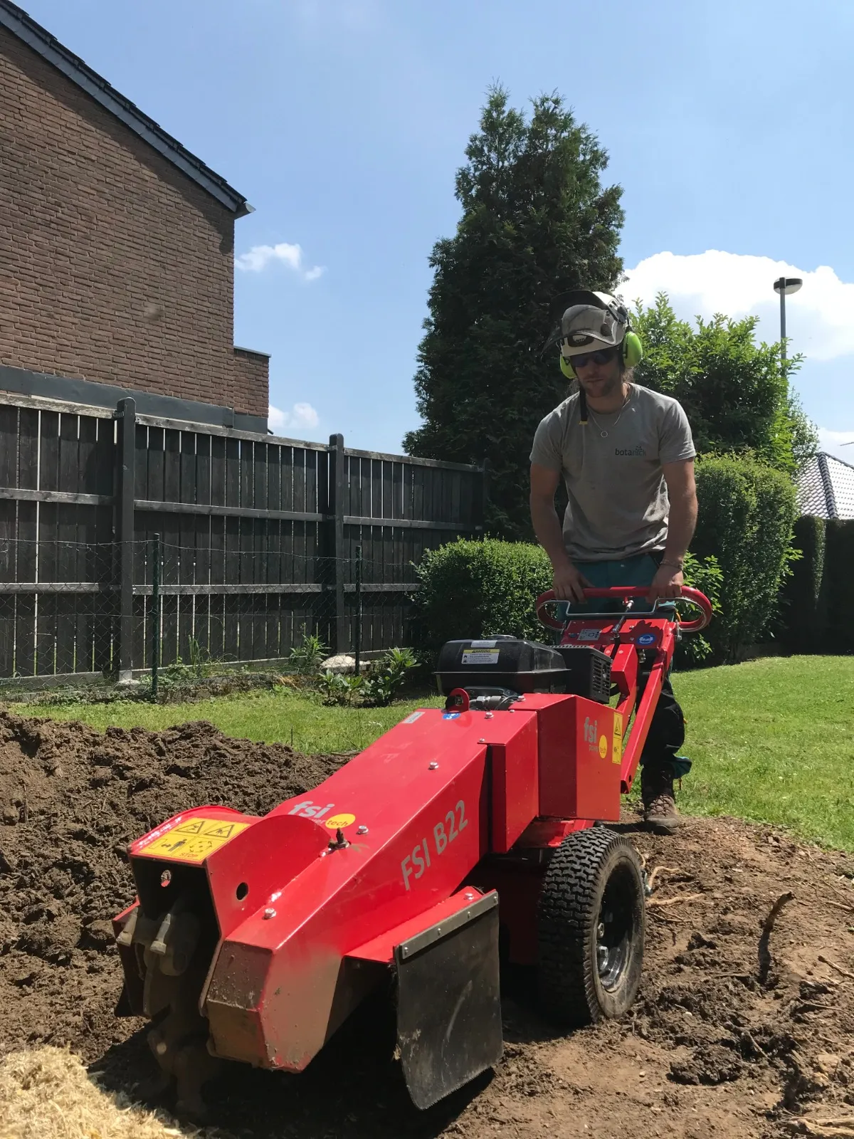 Wurzelstockfräse im Einsatz auf einem Gartengrundstück